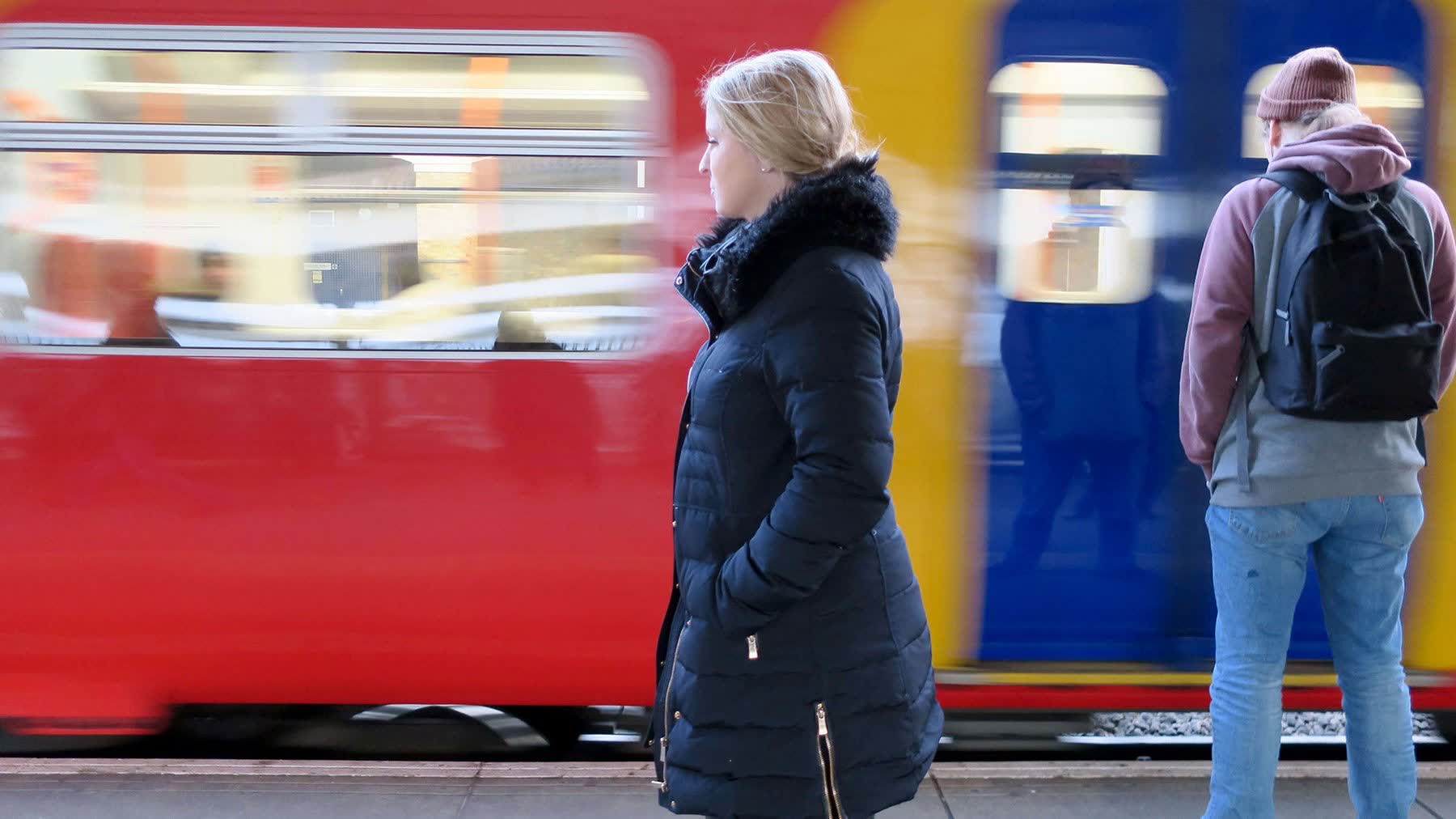Passengers on platform with trains passing